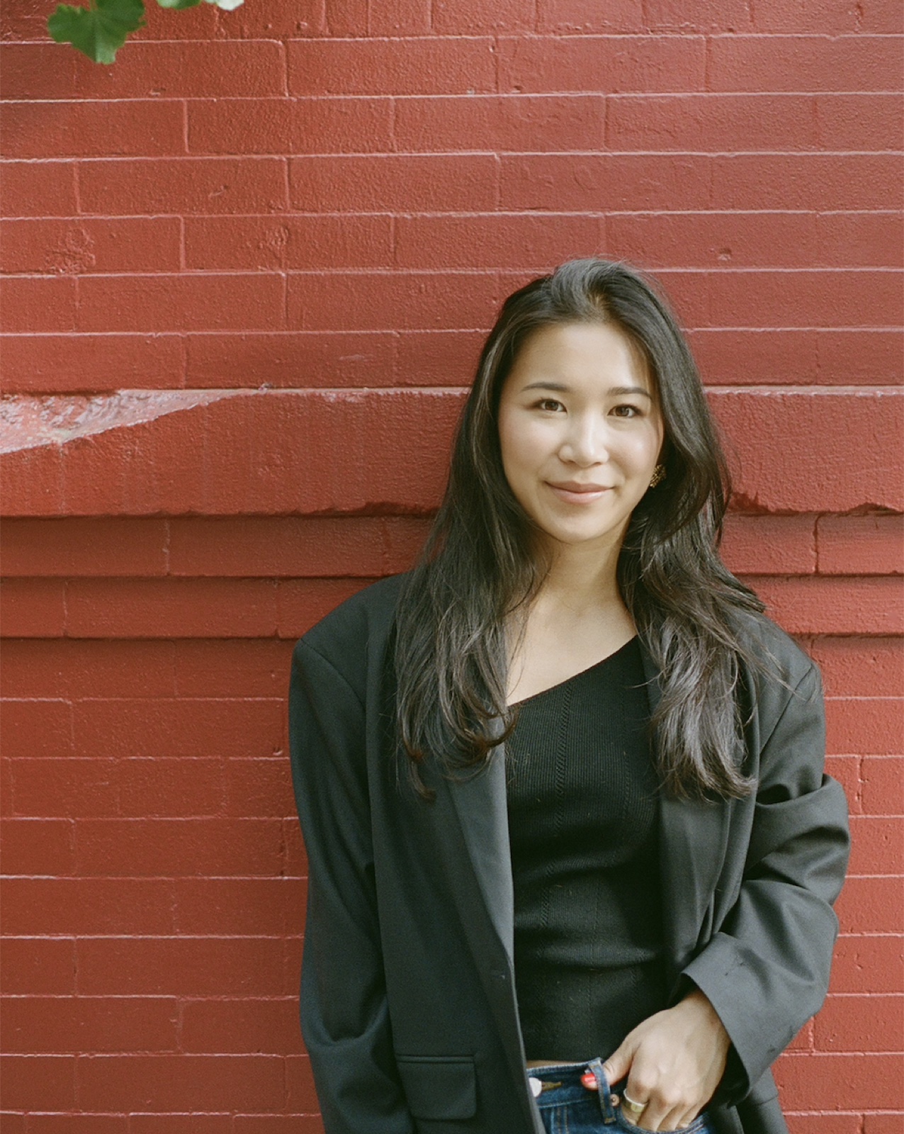 Michelle Yin standing against a red brick wall